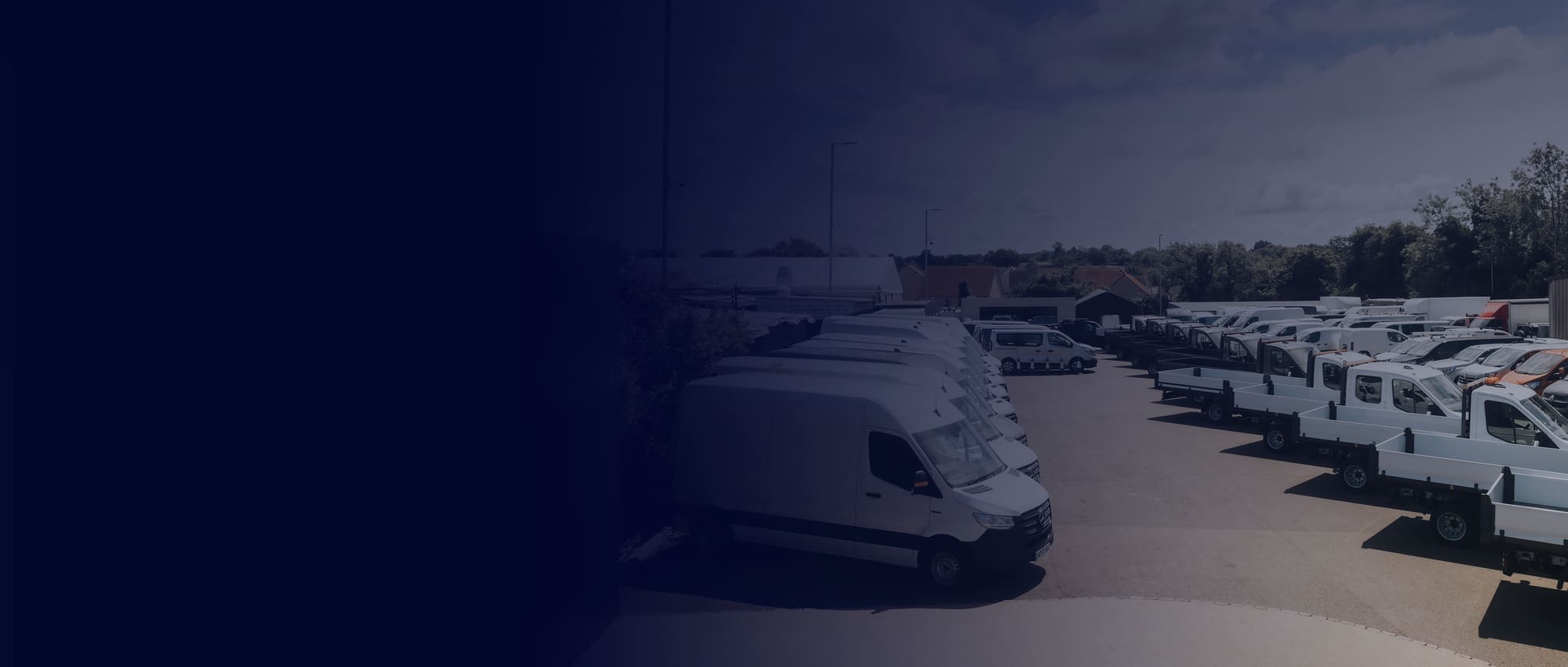 Commercial vans lined up on a forecourt